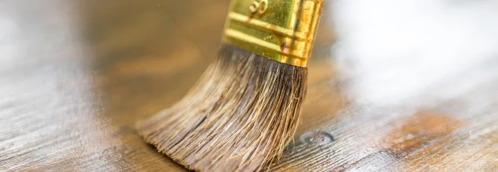 Pinsel trägt Lasur auf Holz auf